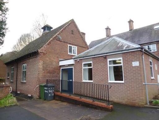 Large old brick cottage with modern extension, a ramp at the front leads to the entrance. 