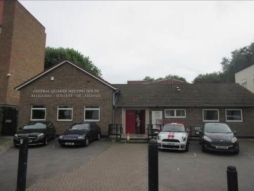 Brick bungalow and car park with large lettering reading 'Central Quaker Meeting House, Religious Society of Friends'.