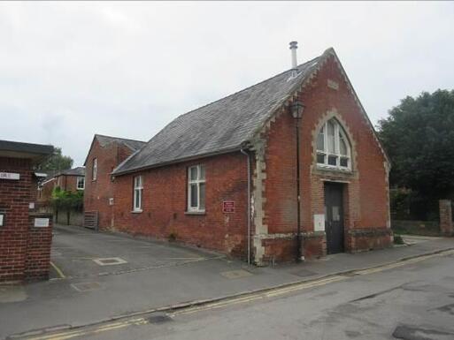 Red brick building with car park, there is no garden on premises.