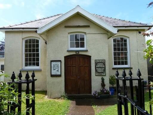 Plain but elegant small white late- Georgian house with a wooden door.