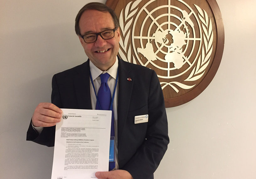 Man holding paper in front of United Nations sign