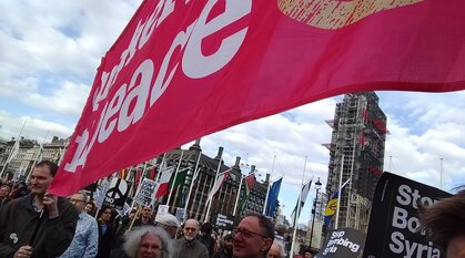 Quakers holding a pink Quakers for peace banner at a demonstration against bombing Syria in Parliament Square