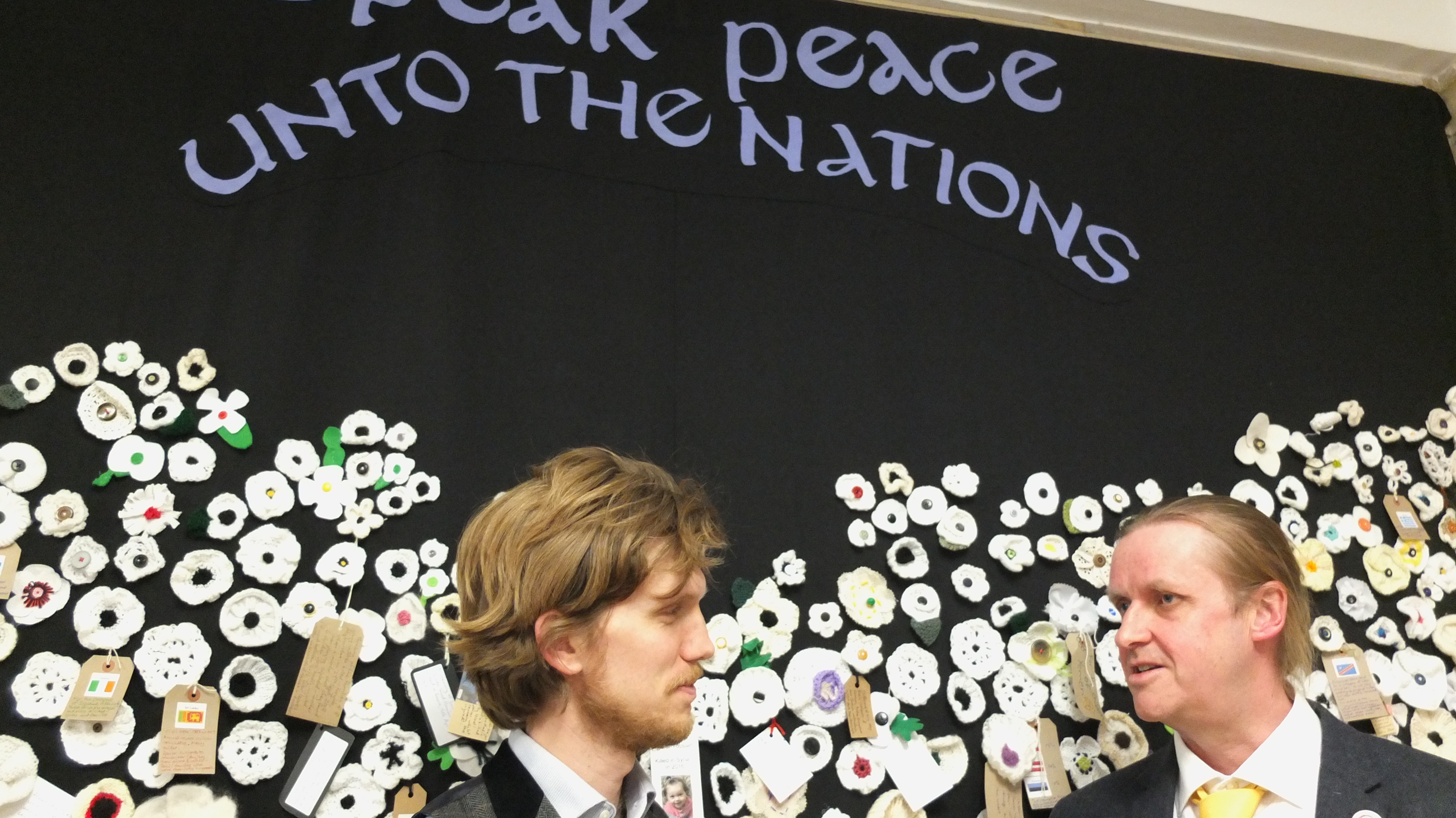 two men by white poppy display