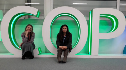 Two people sitting in the letters C and O of COP 