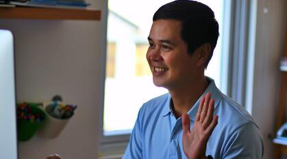 Man waving to monitor