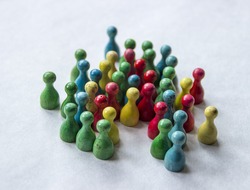 different coloured game pieces /meeples clustered together looking like they're having a conversation