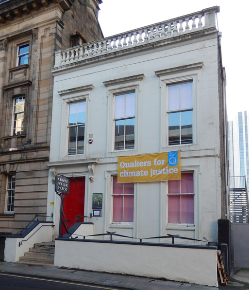 White terraced townhouse with a large freestanding sign in its small front courtyard.