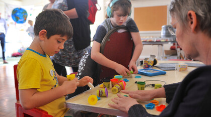 children interacting with Wendy Hampton, a local development worker