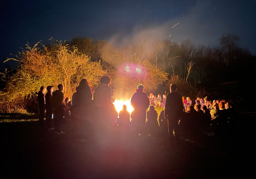 Figures around a bonfire in the dark