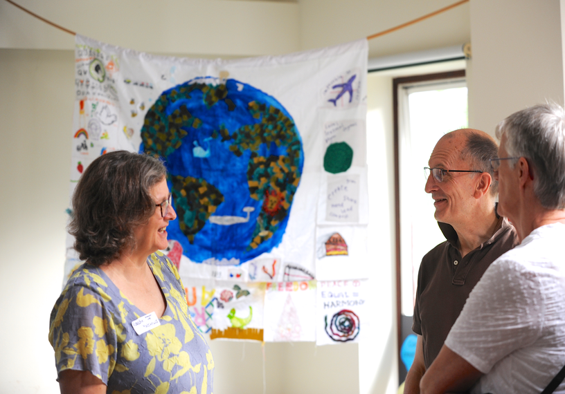 Three people talking in front of bright banner