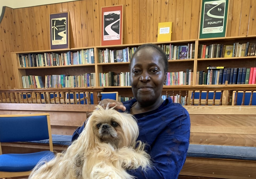 woman with dog in front of book shelves