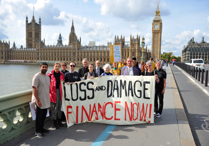 Protestors holding banners in front of Palace of Westminster