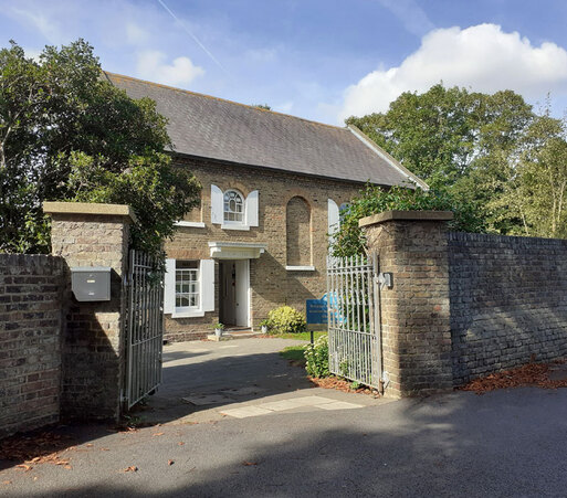 Brick house with filled-in arched windows. Iron gates.