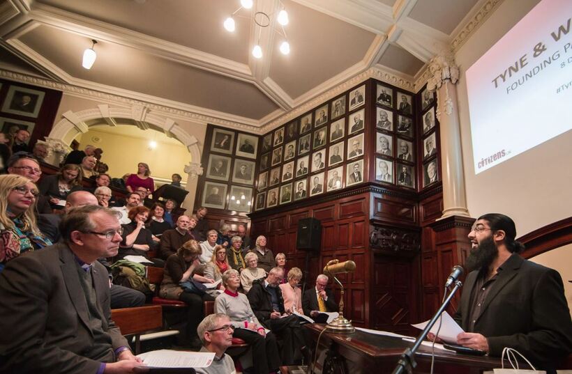 a person giving a speech to a room full of people