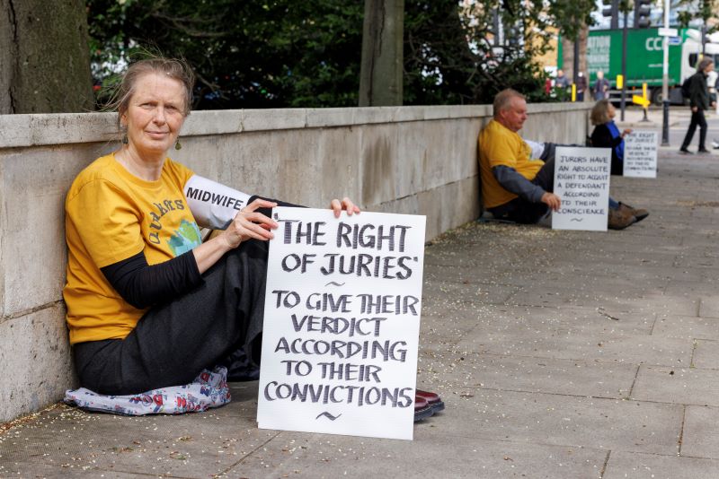 seated woman holding placard