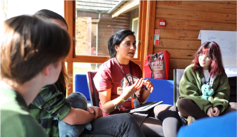 young people sitting on chairs chatting animatedly