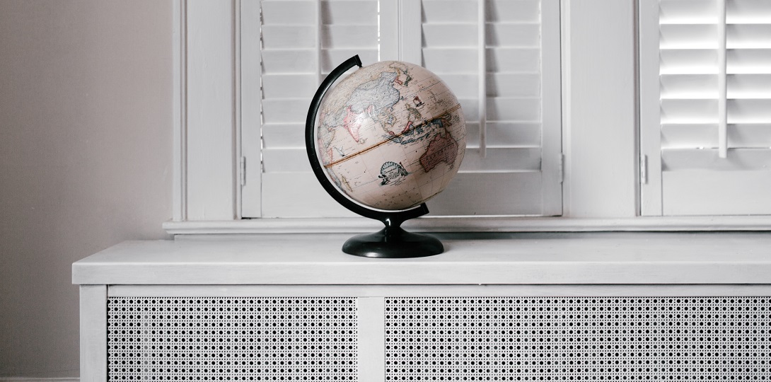 A white globe on a white table against a white background