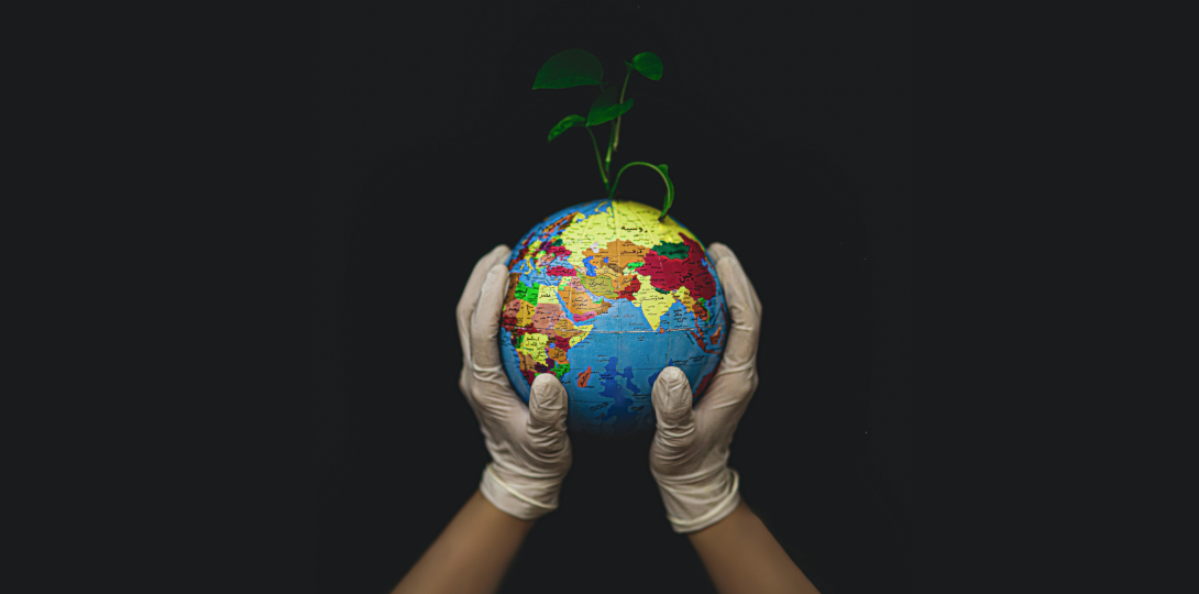 Two gloved hands holding a globe