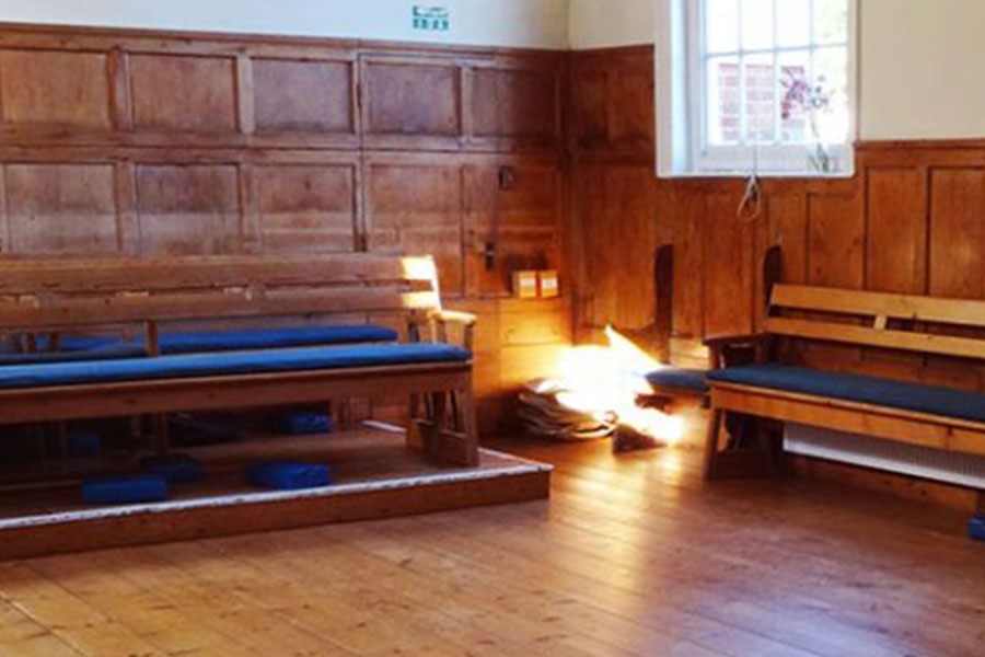 Wooden clad room with wooden floor and benches and light shining in.