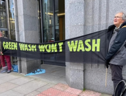 Two Quakers hold a "Greenwash won't wash" banner outside Shell's offices in the Silver Fin Building in Aberdeen