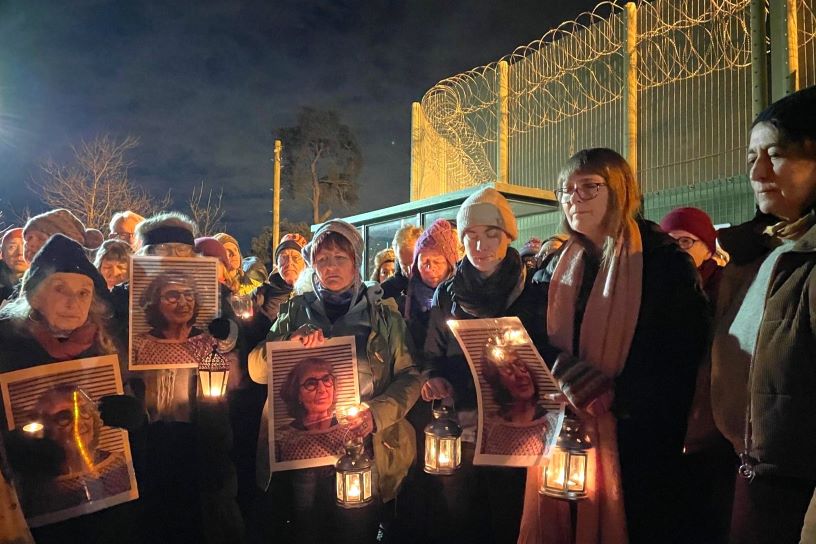 People holding candles and photographs