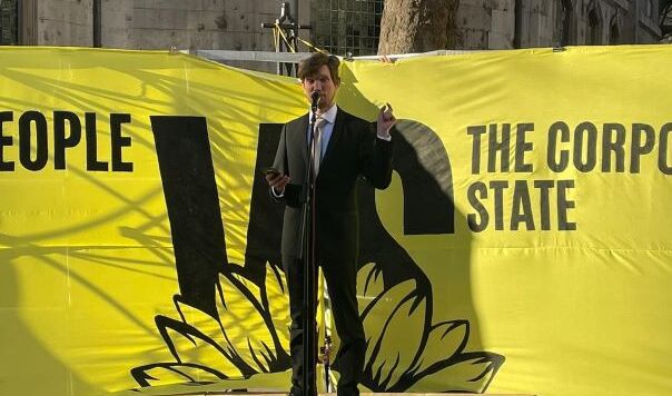 man in front of yellow banner