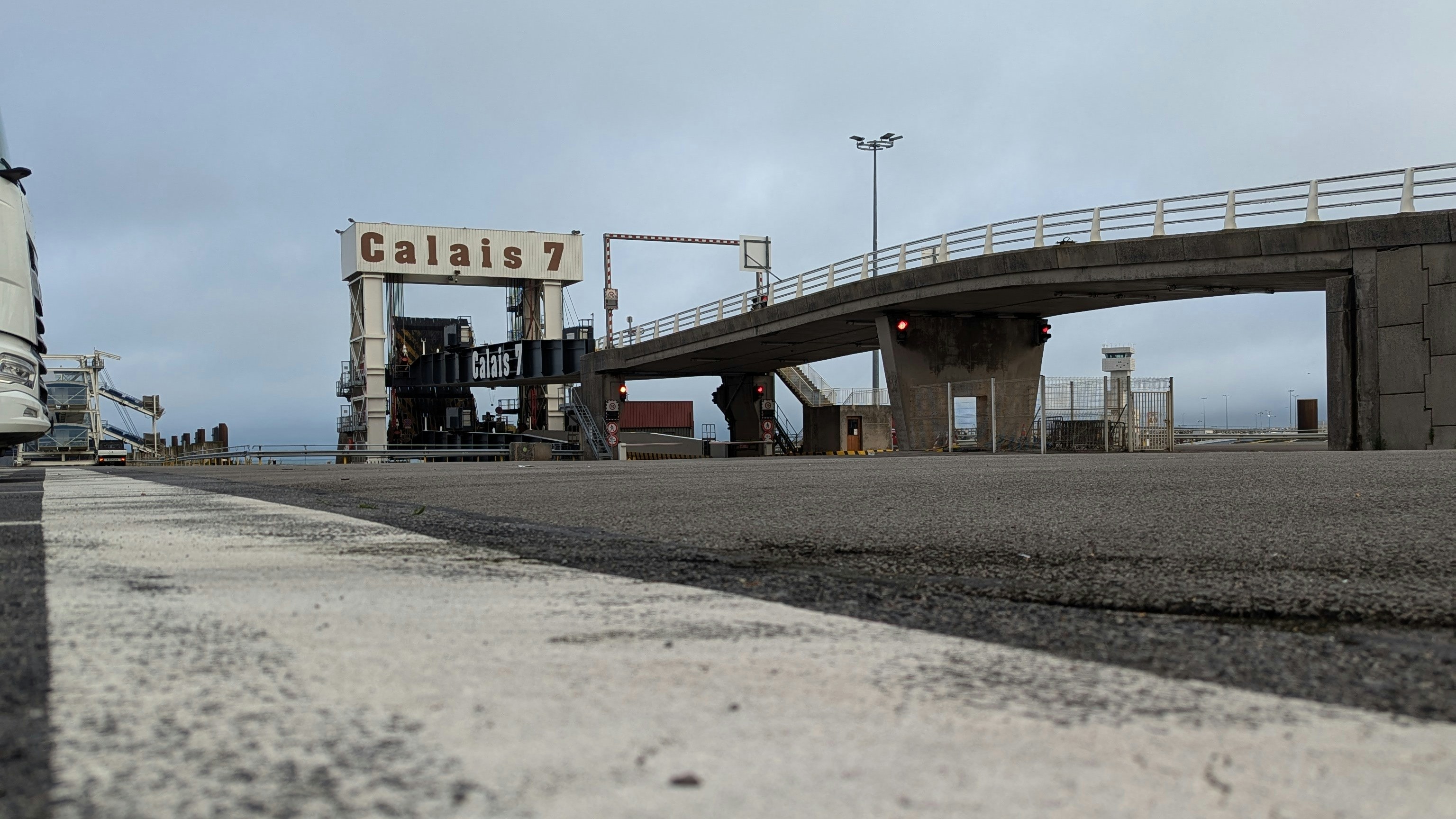 Gate 7 at the port of Calais on a grey day with a misty sea in the background. The nose of a lorry appears on the edge of the photo.