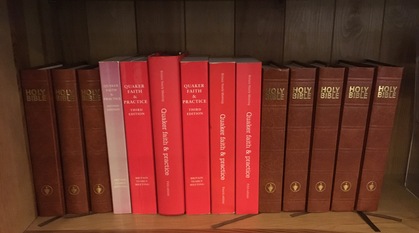 A photo of a bookshelf at Swarthmoor Hall, copies of Quaker Faith and Practice sit between leather bound copies of the Bible