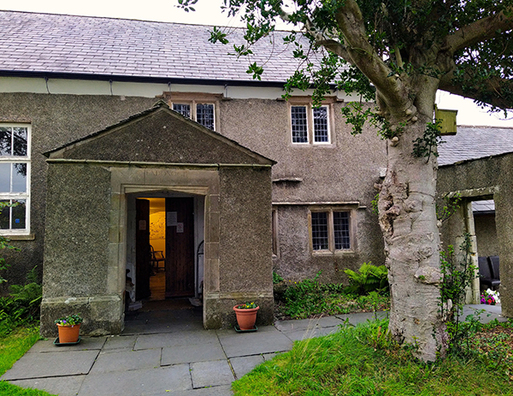 Grey stone, two storey building with protruding porch 