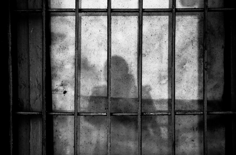State-sanctioned murder has a brutalising effect on society. Image: <a href="https://unsplash.com/@yejinghan?utm_source=unsplash&utm_medium=referral&utm_content=creditCopyText">Ye Jinghan</a> on <a href="https://unsplash.com/photos/a-shadow-of-a-person-behind-bars-in-a-jail-cell-T5roX1jajzU?utm_source=unsplash&utm_medium=referral&utm_content=creditCopyText">Unsplash</a>.